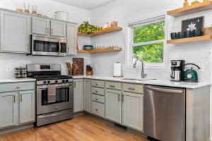 a kitchen with white cabinets and stainless steel appliances at Bohemian Retreat in Traverse City +31 photos