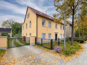 a house with a fence in front of it at Ysenberc Apartments in Moritzburg