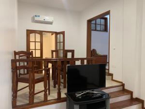 a living room with a table and chairs and a television at Two Bedroom Condo, Mindelo in Mindelo