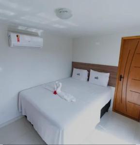 a bedroom with two white beds and a wooden cabinet at WS Beach Pousada in Porto De Galinhas