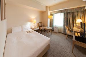 Postel nebo postele na pokoji v ubytování Kobe Seishin Oriental Hotel