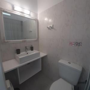 a bathroom with a toilet and a sink and a mirror at Flora Rooms & Apartments in Naousa +35 photos
