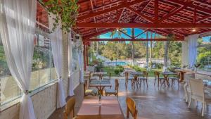 a room with tables and chairs and windows at Pousada Boutique Mercedes in Extrema