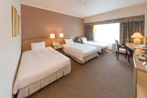 Postel nebo postele na pokoji v ubytování Kobe Seishin Oriental Hotel