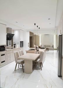 een grote witte keuken met een tafel en stoelen bij Halimah 3BR Luxury Apt-Der Ghbar in Amman