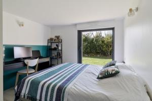 a bedroom with a bed and a desk and a window at Beautiful new ocean facing villa in Anglet