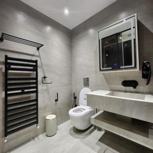 een badkamer met toilet, wastafel en raam bij Halimah 3BR Luxury Apt-Der Ghbar in Amman