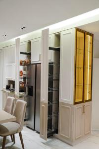 een keuken met witte kasten en een tafel en stoelen bij Halimah 3BR Luxury Apt-Der Ghbar in Amman