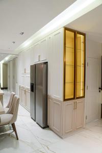 een keuken met witte kasten en een koelkast bij Halimah 3BR Luxury Apt-Der Ghbar in Amman +13 foto's