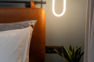 a bed with a white pillow and a lamp at MOD 15 City Centre in Agios Nikolaos