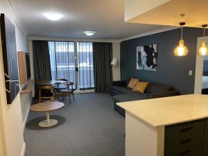 a living room with a couch and a table at Spacious One-Bedroom or Studio with Balcony in Sydney +22 photos