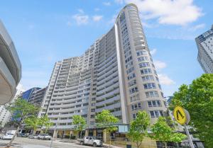 a tall white building with cars parked in front of it at Spacious One-Bedroom or Studio with Balcony in Sydney