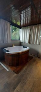 a large bath tub in a room with a window at Pousada Bégamo - Vale dos Vinhedos l Suítes Gran Reserva in Bento Gonçalves +46 photos