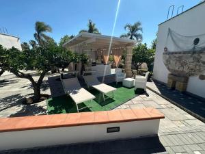 a patio with white chairs and a gazebo at B&B Angolo Magico in Baia Di Gallipoli