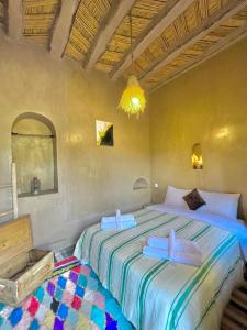 a bedroom with a large bed with two towels on it at Heritage House Skoura in Skoura +47 photos