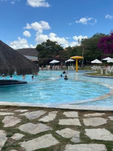 a swimming pool with people in the water at Flat monte castelo condomínio in Bezerros