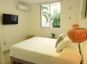 - une chambre avec un lit, une télévision et une fenêtre dans l'établissement Beautiful oasis of peace in the heart of Pradomar!, à Puerto Colombia
