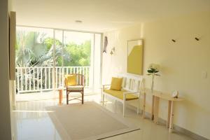 un salon avec une chaise, un bureau et une fenêtre dans l'établissement Beautiful oasis of peace in the heart of Pradomar!, à Puerto Colombia