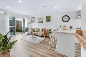 a white kitchen and living room with a counter top at River City Retreat! King Bed & Central - By KOSH BNB in Hamilton +19 photos
