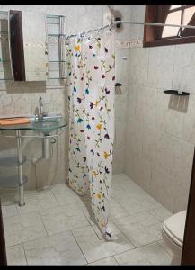 a bathroom with a shower curtain with butterflies on it at Casa temporada Monsuaba in Angra dos Reis