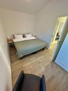 a bedroom with a bed and a chair in it at Farmer's Guest House in Hella