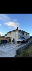 胡萨维克Álfhóll 4 house in Húsavík with oceanview的停在房子前面的停车场的汽车