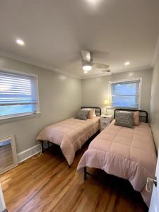 zwei Betten in einem Zimmer mit zwei Fenstern in der Unterkunft Cape Bay Cottage in Cape May