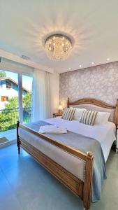 a bedroom with a large bed and a chandelier at Pousada Villa Vie in Gramado