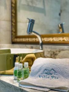 a towel and two bottles on a sink in a bathroom at Pousada Villa Vie in Gramado