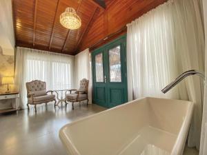 a bathroom with a tub and a table and chairs at Pousada Villa Vie in Gramado +116 photos