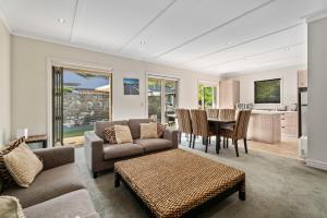 ein Wohnzimmer mit Sofa und Tisch in der Unterkunft Kiwi Ski Cottage - Wanaka Holiday Home in Cardrona