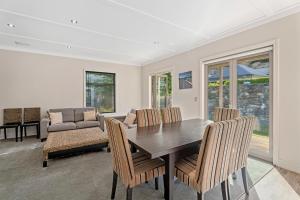 ein Esszimmer mit Tisch und Stühlen und einer Couch in der Unterkunft Kiwi Ski Cottage - Wanaka Holiday Home in Cardrona