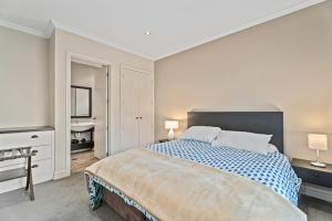 ein weißes Schlafzimmer mit einem großen Bett und einem Waschbecken in der Unterkunft Kiwi Ski Cottage - Wanaka Holiday Home in Cardrona + 16 Fotos