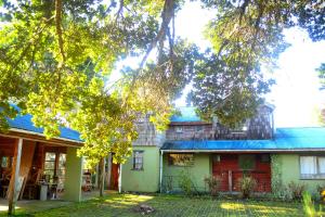 a house with a tree in front of it at Casa Nelson Rural Puerto Montt in Puerto Montt