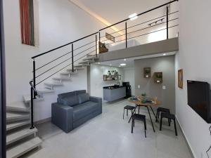 a living room with a staircase and a table and chairs at Lofts Indaiatuba in Indaiatuba