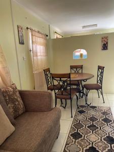 a living room with a couch and a table and chairs at Sasha’s Holiday Home Oistins Barbados in Christ Church