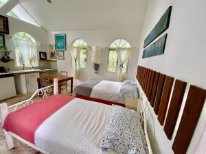 a bedroom with two beds and a kitchen at Casa del Arquitecto in Cancún