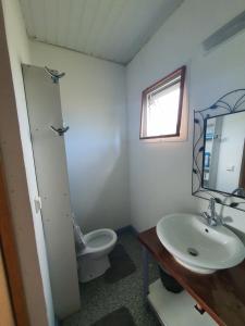 a bathroom with a toilet and a sink and a mirror at Bungalow B1 in Kumak