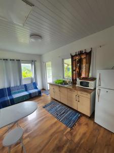a kitchen and living room with a white refrigerator at Bungalow B1 in Kumak