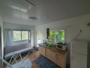 a kitchen with a couch and a microwave in it at Bungalow B1 in Kumak +8 photos