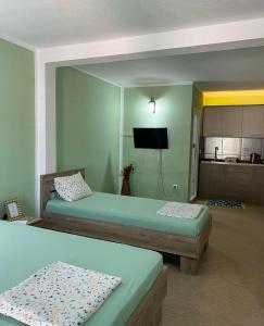 a room with two beds and a television in it at Fenix Apartmani Dubrava in Dobra Voda