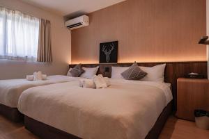 two beds in a hotel room with white pillows at Apartment Hotel 11 Villa Tengachaya in Osaka