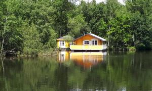 a house on a boat in the middle of a lake at Chalet flottant sur lac et spa in Mios