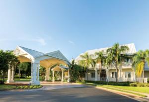 ein großes weißes Haus mit Palmen in der Unterkunft WorldMark Orlando Kingstown Reef in Orlando