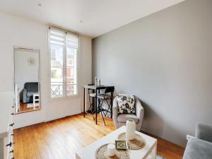una sala de estar con una mesa y una silla en Fully equipped modern studio -2P- Levallois-Perret, en Levallois-Perret 2 fotos más