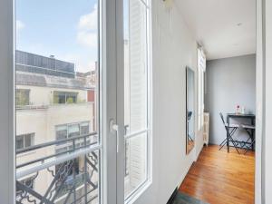 una puerta abierta a un balcón con ventana en Fully equipped modern studio -2P- Levallois-Perret, en Levallois-Perret