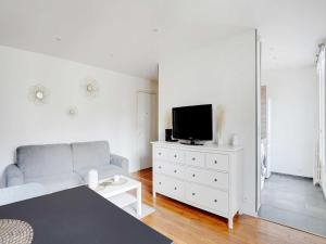 sala de estar con sofá y tocador con TV en Fully equipped modern studio -2P- Levallois-Perret, en Levallois-Perret