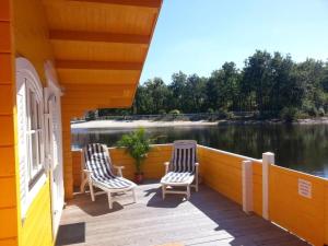 two chairs sitting on the deck of a house at Chalet flottant sur lac et spa in Mios