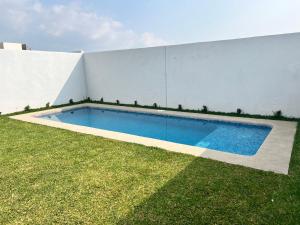 a swimming pool in a yard next to a building at Casa con Alberca privada en Cuernavaca in Ahuatepec