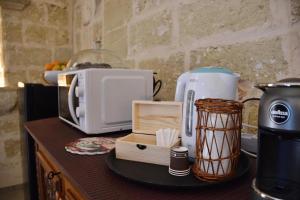 a counter with a coffee maker and a microwave at Suite Palazzo Palmieri in Martignano
